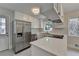 Bright eat-in kitchen with stainless refrigerator, white cabinets, stone countertops, and stylish lighting at 4253 Smithsonia Dr, Tucker, GA 30084