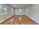 Empty room with hardwood flooring, featuring trim work and natural light from the windows at 4253 Smithsonia Dr, Tucker, GA 30084