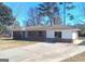 Traditional brick home with a concrete driveway and mature trees against a clear blue sky at 6258 Mount Zion Blvd, Morrow, GA 30260