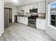 Well-lit kitchen with white cabinetry, stainless steel appliances, and granite countertops at 6420 Wedgeview Dr, Tucker, GA 30084