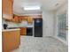 Kitchen featuring wood cabinets, tile flooring, and black appliances at 781 Courthouse Park Dr, Temple, GA 30179