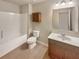 Bright bathroom featuring a tub, a wooden vanity, and a mirrored medicine cabinet at 1340 Apple Blossom Dr, Cumming, GA 30041