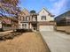 Charming brick and siding home featuring a two-car garage, and inviting curb appeal at 1340 Apple Blossom Dr, Cumming, GA 30041