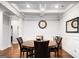 Bright dining room boasts coffered ceilings, wainscoting, and a modern round wood table at 165 Ruby Ln, Mcdonough, GA 30252