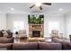 Cozy living room featuring a stone fireplace with mounted TV, hardwood floors, and comfortable seating at 165 Ruby Ln, Mcdonough, GA 30252