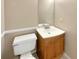 Cozy powder room with wooden vanity, sink, and toilet at 166 Floresta Dr, Mcdonough, GA 30252