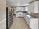 Well-lit kitchen with white cabinets, stainless steel appliances, and tile floors at 166 Floresta Dr, Mcdonough, GA 30252