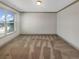 An empty carpeted bedroom featuring natural light from the large window at 3308 Steeple Chase Sw Way, Conyers, GA 30094