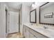 Bathroom featuring double sinks, cabinet and an open doorway to an adjacent closet at 4080 Huron Dr, Cumming, GA 30028