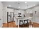 A kitchen island features seating, stainless steel appliances, and white cabinets at 4080 Huron Dr, Cumming, GA 30028