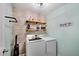 Efficient laundry room with stacked washer and dryer, custom shelving, and a modern, industrial design at 4080 Huron Dr, Cumming, GA 30028