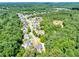 Expansive aerial view of a neighborhood in a dense forest, marked with yellow pin at 6690 Bridge Brook Ovlk, Cumming, GA 30028