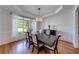 Elegant dining room featuring hardwood floors, wainscoting, and a stylish chandelier at 6690 Bridge Brook Ovlk, Cumming, GA 30028