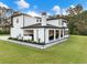 Stylish back of the house showcasing an outdoor kitchen, covered patio, and expansive lawn at 2940 Old Peachtree Rd, Dacula, GA 30019