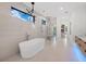 Luxurious bathroom with a soaking tub, glass-enclosed shower, modern fixtures, and access to a custom closet at 2940 Old Peachtree Rd, Dacula, GA 30019