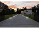 Long driveway to a newly-constructed luxury home with lights, professional landscaping, and privacy gate at 2940 Old Peachtree Rd, Dacula, GA 30019