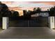 Modern gate with home number leads to a newly-constructed luxury home at dusk at 2940 Old Peachtree Rd, Dacula, GA 30019