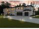 Stunning modern home exterior with expansive windows and a well-manicured lawn at dusk at 2940 Old Peachtree Rd, Dacula, GA 30019