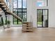Bright, modern foyer with floating staircase, floor-to-ceiling windows, and sleek design features at 2940 Old Peachtree Rd, Dacula, GA 30019