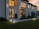 Modern home featuring a front entry, walkway lighting, lush landscaping, and oversized windows at 2940 Old Peachtree Rd, Dacula, GA 30019