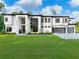 Stunning modern home featuring a crisp white facade, expansive windows, and a meticulously manicured lawn at 2940 Old Peachtree Rd, Dacula, GA 30019