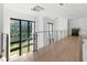Bright hallway with glass railing, modern lighting, and hardwood floors creating an open and airy atmosphere at 2940 Old Peachtree Rd, Dacula, GA 30019