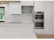Kitchen with double ovens, cooktop, and sleek cabinets at 2940 Old Peachtree Rd, Dacula, GA 30019