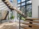 Elegant floating staircase with wood treads, glass railings, and ample natural light from large windows at 2940 Old Peachtree Rd, Dacula, GA 30019