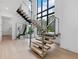 Stylish floating staircase with glass railings and pendant lighting, complemented by large windows at 2940 Old Peachtree Rd, Dacula, GA 30019