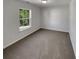 Cozy bedroom with neutral carpet, a large window, and freshly painted walls at 2985 Whittier Way, Cumming, GA 30040
