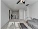 Bright, spacious bonus room featuring a sectional, staircase, and ceiling fan, ideal for relaxation and activities at 4825 Odum View Ln, Cumming, GA 30040