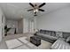 Open bonus room with a gray sectional, ceiling fan and a staircase, offering a versatile living area at 4825 Odum View Ln, Cumming, GA 30040