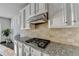 Modern kitchen featuring granite countertops, stainless steel appliances, and gas cooktop at 4825 Odum View Ln, Cumming, GA 30040
