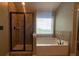 Modern bathroom featuring a shower, tub, and bright natural light from the window at 5928 Cobblestone Creek Cir, Mableton, GA 30126