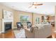 Bright living room featuring a fireplace, hardwood floors, comfortable seating, and a view of the kitchen and backyard at 5928 Cobblestone Creek Cir, Mableton, GA 30126