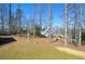 View of backyard with trees and bird bath, and neighboring house in the background at 6450 Oak Valley Dr, Cumming, GA 30040