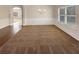 Spacious carpeted room featuring chair rail, wainscotting, large windows, and hardwood floors at 1181 Paramount Dr, Mcdonough, GA 30253