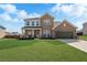 Charming two-story brick home featuring a manicured lawn and an attached two-car garage at 236 Himalaya Way Way, Mcdonough, GA 30253