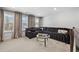 Living room with dark corduroy sectional, carpet, windows with drapes, and a glass coffee table at 236 Himalaya Way Way, Mcdonough, GA 30253