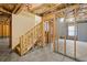 Unfinished basement featuring exposed beams, electrical wiring, and a staircase leading upstairs at 847 Sand Ln, Lawrenceville, GA 30045