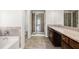 Modern bathroom with a tub, separate shower, granite countertops, and tile floors at 847 Sand Ln, Lawrenceville, GA 30045