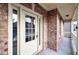 Close-up of the front door with glass panels, framed by brick and a covered porch area with white railing at 847 Sand Ln, Lawrenceville, GA 30045