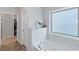 Bright bathroom featuring a soaking tub beneath a textured window, and an open doorway to the walk-in closet at 1077 Roanoke Ave, Mcdonough, GA 30253