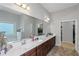Spacious bathroom featuring a large mirror above a double vanity and an open doorway to the walk-in closet at 1077 Roanoke Ave, Mcdonough, GA 30253