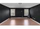 Bonus room features newly refinished hardwood flooring, natural light, and dark walls at 1077 Roanoke Ave, Mcdonough, GA 30253
