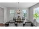 Elegantly decorated dining room with dark wood table, chandelier lighting, and natural light, perfect for Gathering gatherings at 1077 Roanoke Ave, Mcdonough, GA 30253