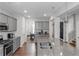 Open kitchen features stainless appliances, gray cabinetry, and an island with granite countertops at 1077 Roanoke Ave, Mcdonough, GA 30253