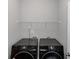 Laundry room featuring modern, high-efficiency washer and dryer set beneath a white wire shelf at 1077 Roanoke Ave, Mcdonough, GA 30253