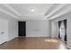 Open-concept living room featuring hardwood flooring, neutral walls, recessed lighting, and privacy curtains at 1077 Roanoke Ave, Mcdonough, GA 30253