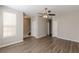 Well-lit living room with wood-look floors, neutral walls, and a ceiling fan and access to a staircase at 2454 Brianna Dr, Hampton, GA 30228